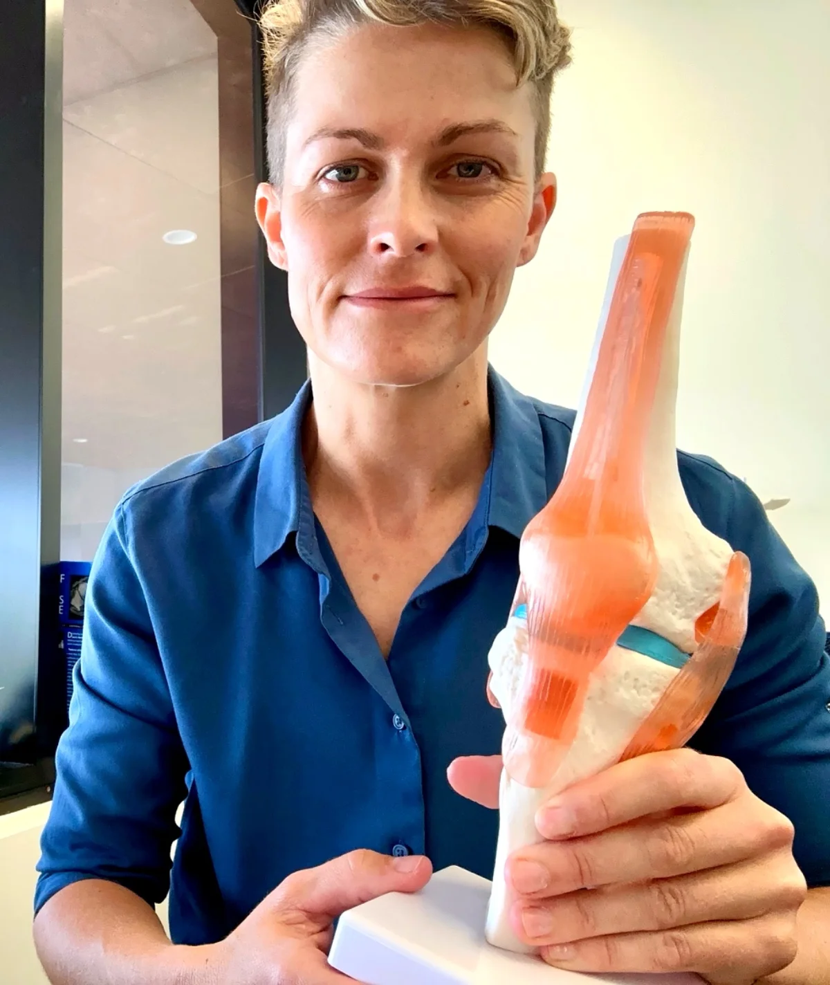 Dr Wells examining knee model in clinic