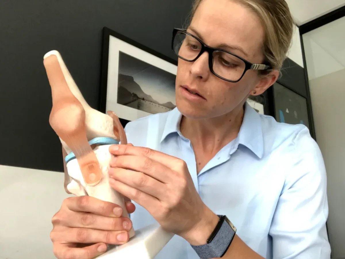 Dr Wells examining a knee model at SportsMed Sunshine Coast